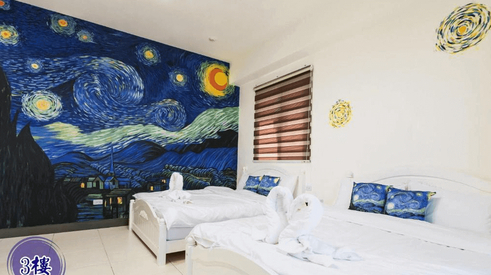 【玉井住宿】藝海民宿三樓的星夜主題四人房，牆面手繪星空《星夜》壁畫極具藝術感，房內配置兩張雙人床，床上擺放著愛心造型毛巾，搭配星空主題抱枕，營造出浪漫夢幻的住宿體驗。