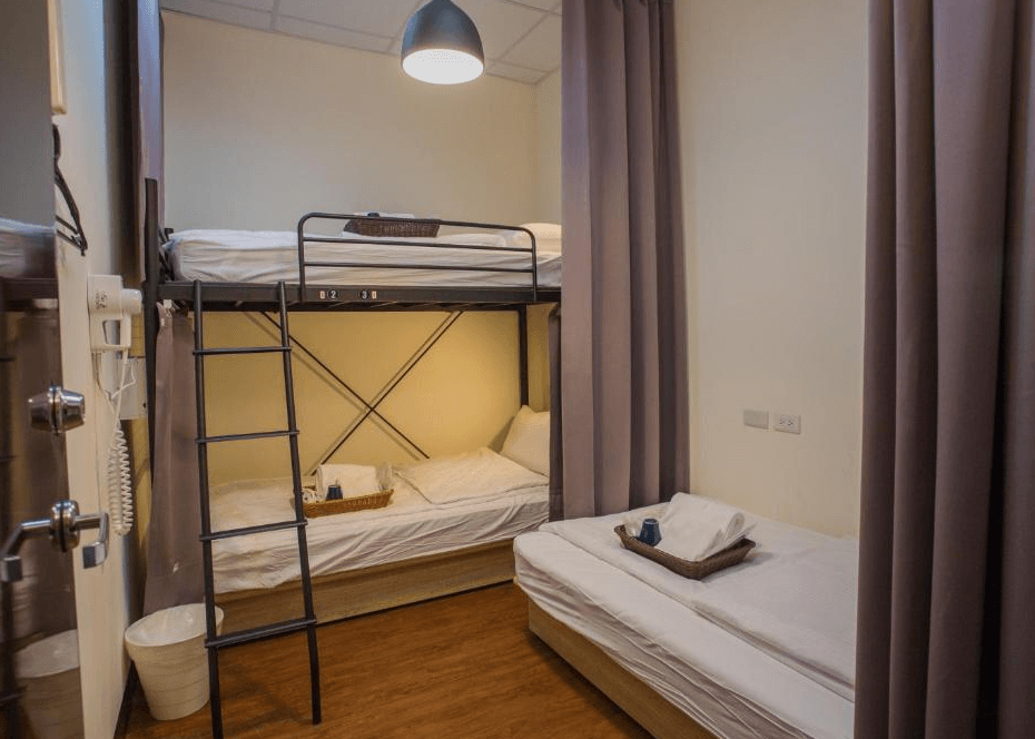 【Xpark住宿】豆子一家輕旅三人房，設有一組上下舖及一張單人床，床鋪擺設整齊，每張床皆附上毛巾與籃裝備品，適合親子或團體入住。