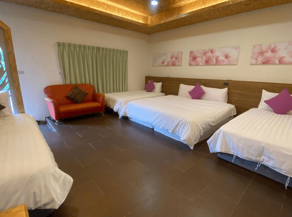 【關山住宿】關山清水莊民宿適合家庭入住的五人房，配置三張床與橘色沙發，粉紅抱枕與櫻花掛畫讓空間更添溫柔感。