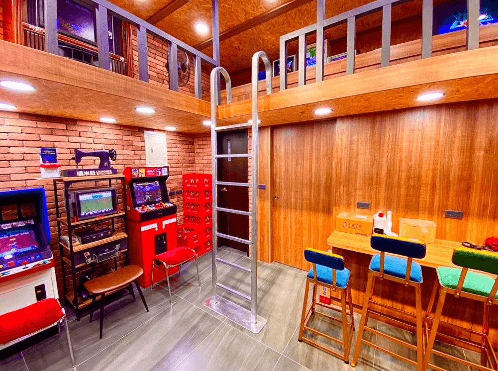 【關山住宿】關山清水莊民宿的復古電玩遊戲空間，配有多台懷舊街機、彈珠台與高腳椅吧檯，木質與紅磚牆面營造出濃濃懷舊氛圍。