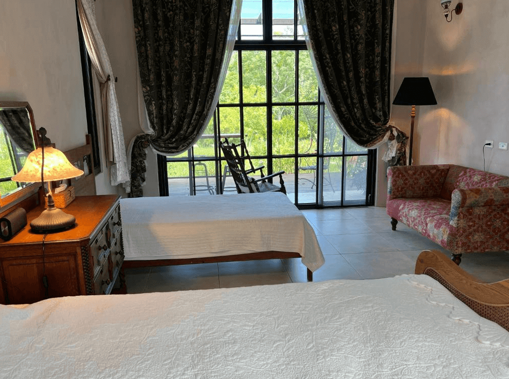 【長濱住宿】陌上草薰民宿典雅雙床房，設有復古木櫃、花布沙發與大片落地窗，可眺望戶外綠意景致，整體風格充滿歐洲鄉村風情。