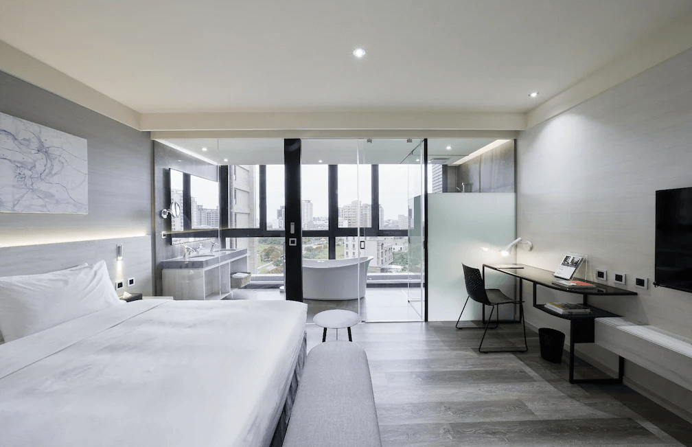 【Xpark住宿】"Xpark住宿精選示意圖"青埔商旅景觀雙人房，房內空間寬敞，配有玻璃隔間衛浴與大面落地窗，窗外可見都市景致，設計簡約現代感十足。