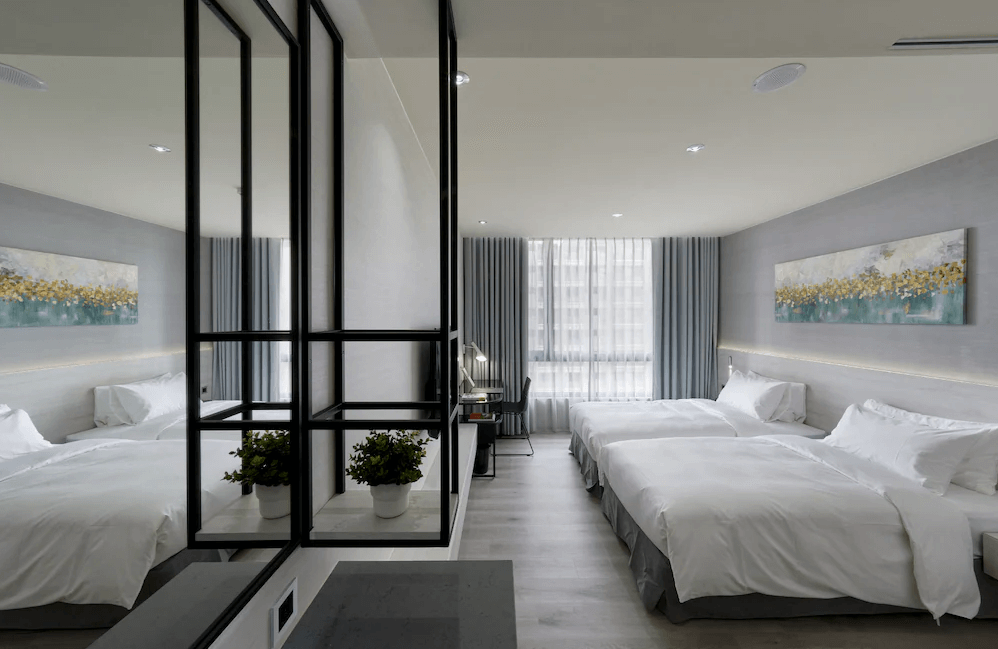 【Xpark住宿】青埔商旅雙床房，擁有兩張大床，牆上掛有藝術畫作與大片窗簾，搭配灰白色調打造出清新舒適的住宿氛圍。