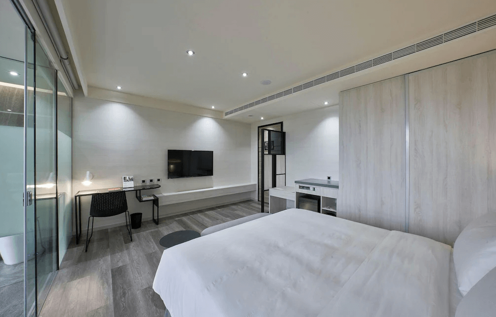 【Xpark住宿】青埔商旅現代雙人房，配有平面電視、書桌與玻璃隔間浴室，整體裝潢走灰白色簡約風格，適合商務與休閒旅客入住。