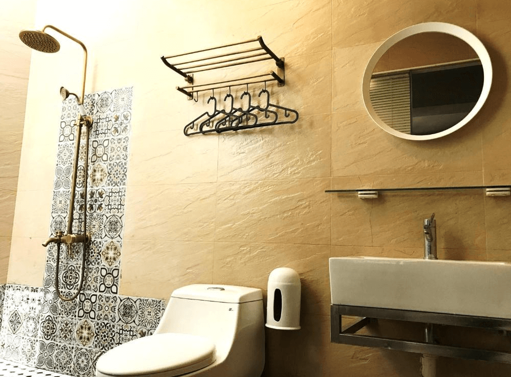 【Xpark住宿】高鐵背包客 HSR B&B 衛浴空間，設有特色花磚淋浴區與現代化洗手台、馬桶，牆上掛有圓鏡與毛巾掛架，風格清新實用。