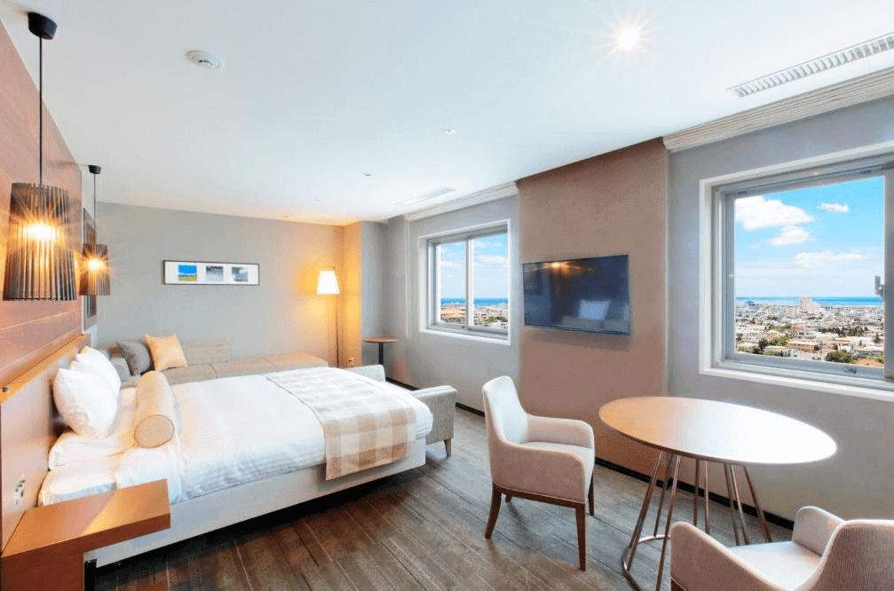 【石垣島住宿】ART石垣島酒店海景雙人房，設有舒適雙人床與沙發床，兩面開窗可遠眺藍天與市景，現代簡約風格適合情侶或小家庭入住。