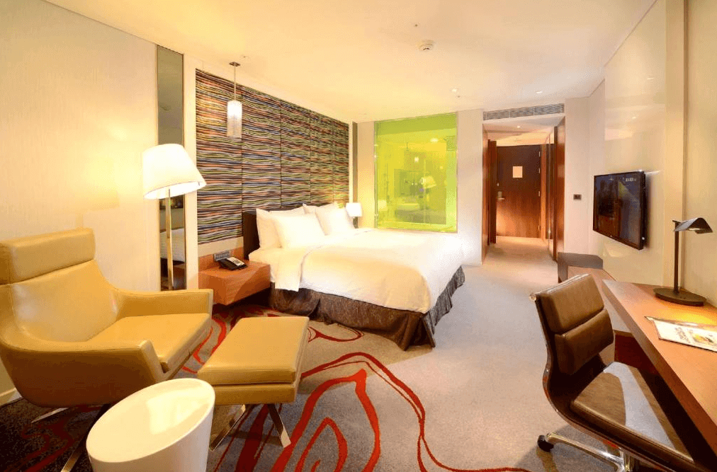 【新竹東區住宿】Fleur Lis 芙洛麗大飯店典雅客房，設有大床、現代風格沙發椅與書桌，牆面繽紛設計增添視覺活力，浴室採透明玻璃設計。