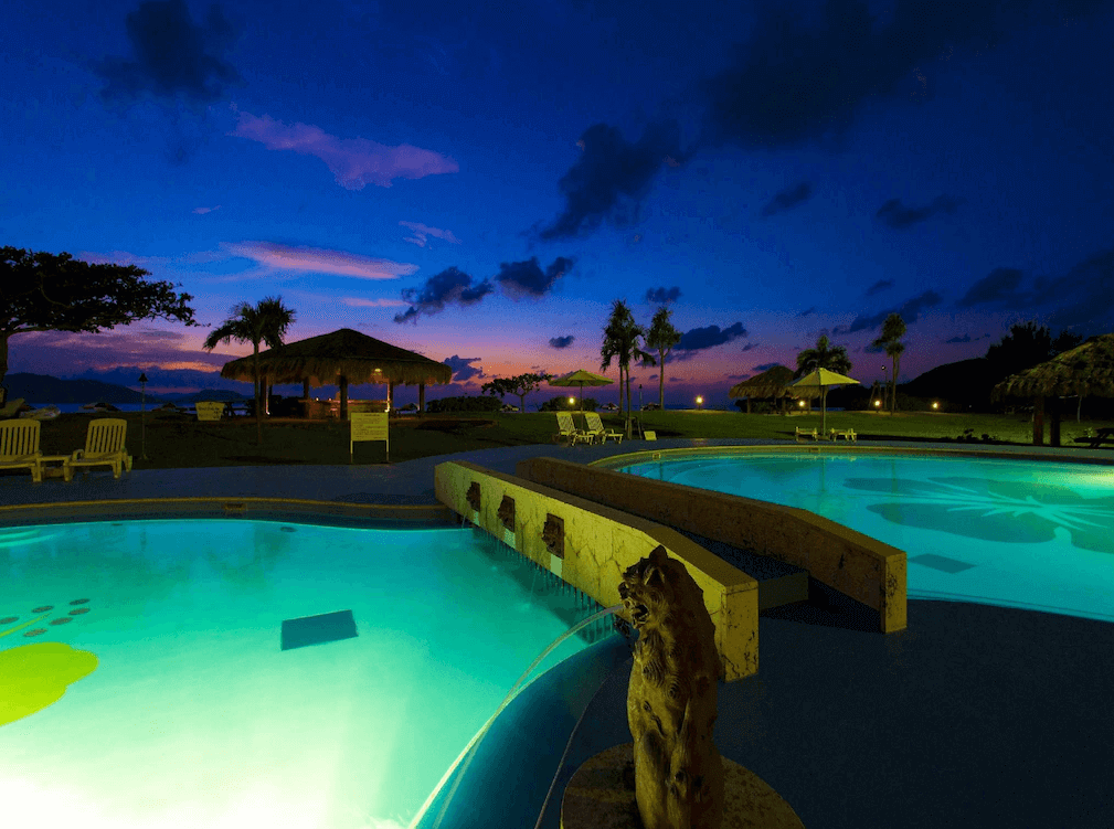 【石垣島住宿】Ishigaki Seaside Hotel 戶外泳池夜景，池水在燈光映照下閃爍夢幻光芒，四周環繞椰子樹與涼亭，營造浪漫放鬆的熱帶氛圍。