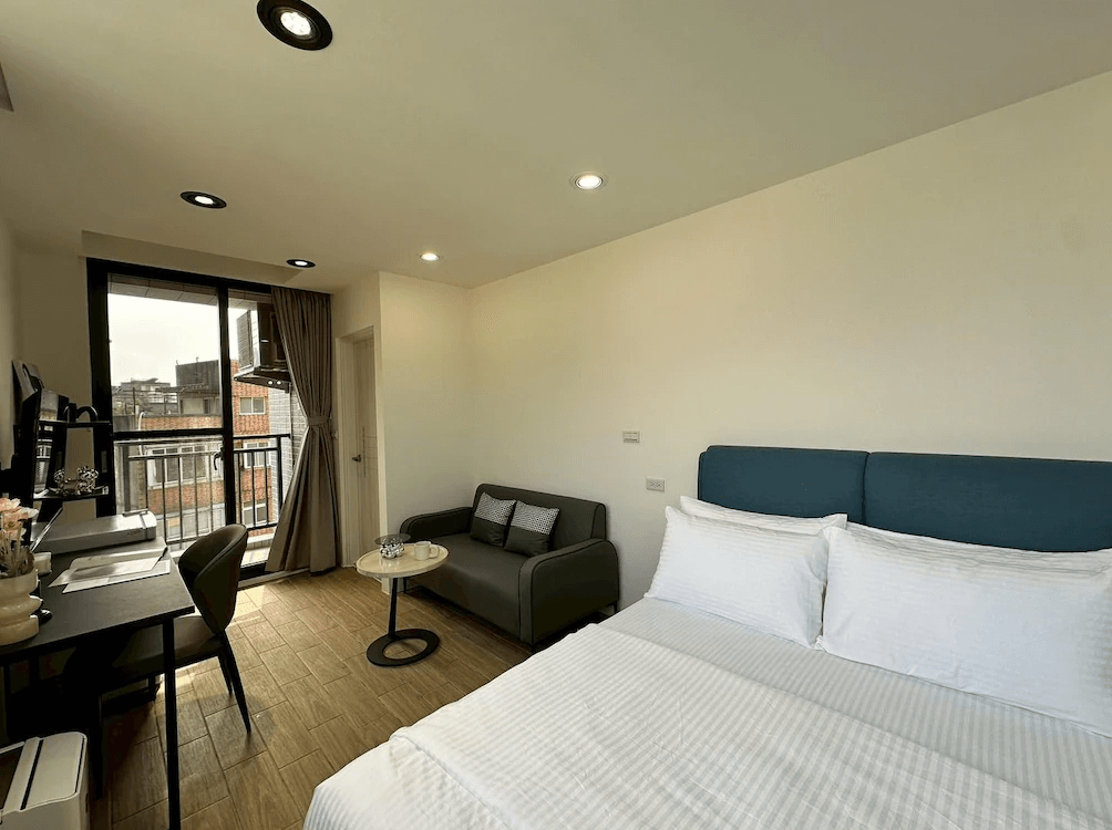 【竹北住宿】NeoStay 新智商旅｜高樓層景觀雙人房，配有大床、沙發與書桌，設有陽台可眺望市景，空間簡約清爽。