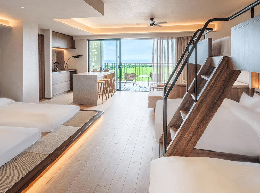【石垣島住宿】seven x seven ISHIGAKI的家庭房型，配有上下舖與和室床區，現代木質設計風格，面海陽台可遠眺蔚藍海景。