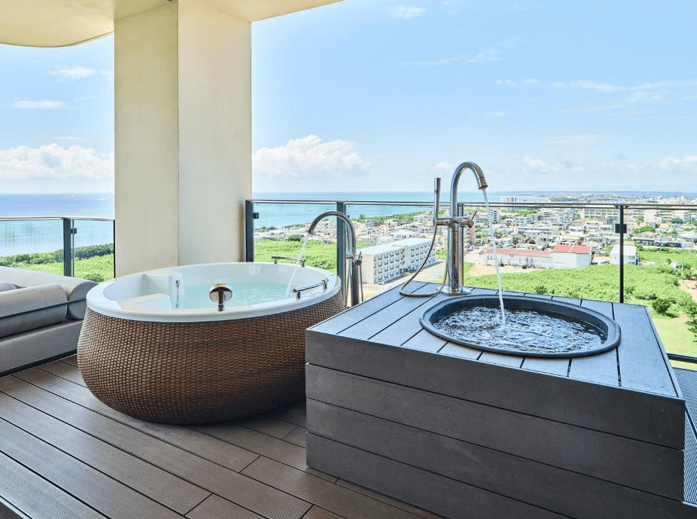 【石垣島住宿】seven x seven ISHIGAKI頂樓露臺設有露天按摩浴缸與圓形冷水浴池，遠眺石垣島城市與海景，是放鬆的絕佳選擇。