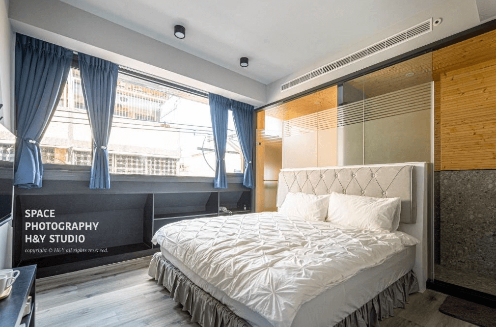 【竹山住宿】一瓢食宿明亮雙人房型，設有大面窗景與白色床組，房內採用木質與玻璃隔間設計，搭配藍色窗簾與簡約北歐風裝潢，提供舒適自在的住宿空間。