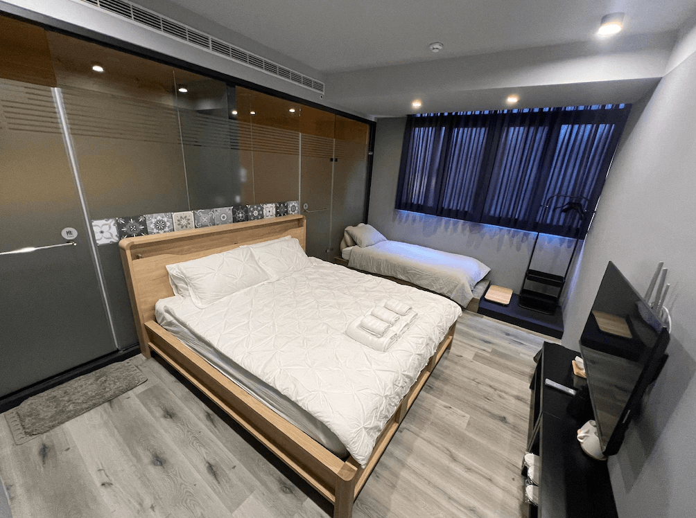 【竹山住宿】一瓢食宿三人房型，設有一張雙人床與一張單人床，大片窗景搭配深色窗簾，整體空間寬敞明亮，適合小家庭或朋友同行入住。