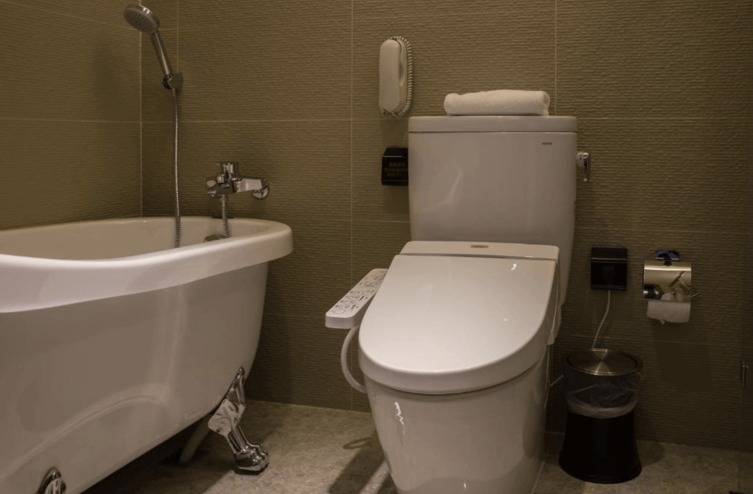 【中壢夜市住宿】三揚精品商旅浴室設施一景，配有復古造型浴缸與免治馬桶，空間乾淨整潔，提升住宿舒適度。