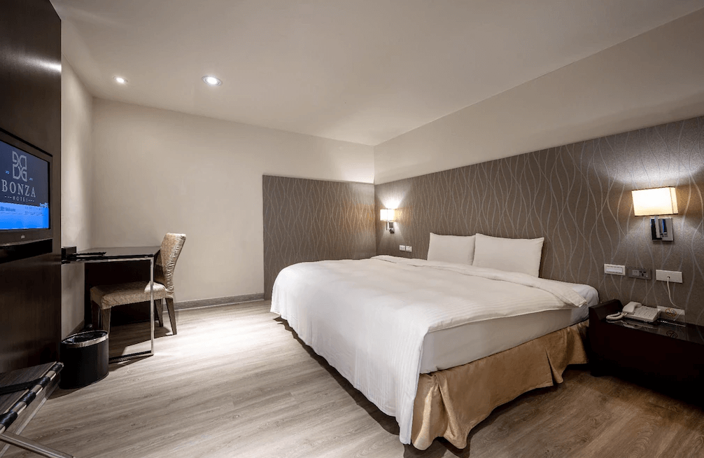 【竹北住宿】享豪大飯店經濟雙人房，牆面設計典雅，搭配柔和燈光與工作書桌，適合商務旅客短期住宿。