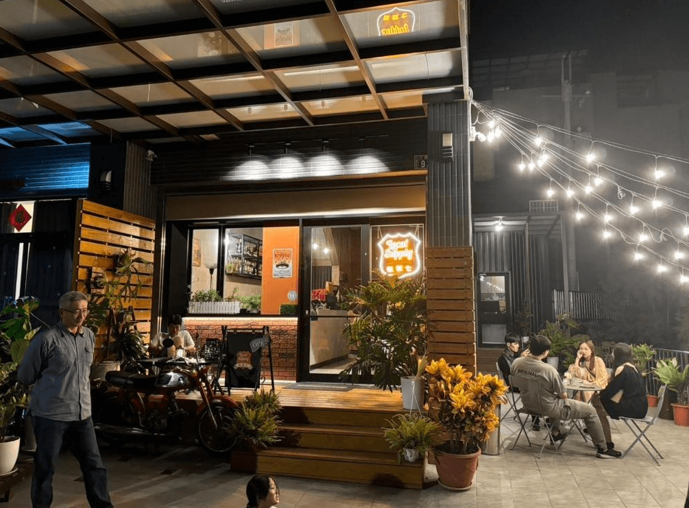 【竹山住宿】伍伍七 Local Supply 戶外酒吧與咖啡館空間，傍晚燈光點綴溫暖氛圍，客人自在地於露天座位聊天用餐，營造放鬆愜意的社交場域。