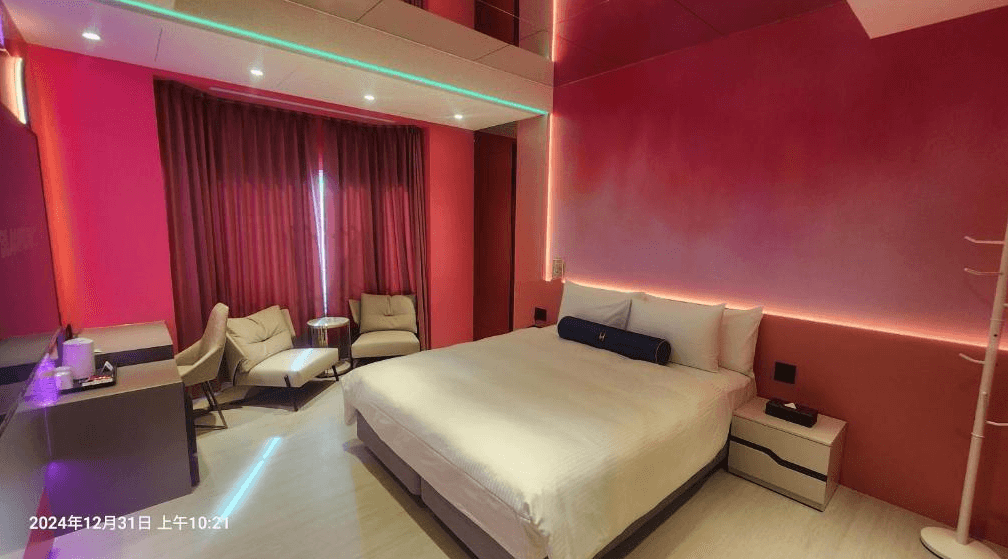 【竹北住宿】佳緹國際精品旅館｜夢幻粉紅主題雙人房，搭配現代燈光設計與舒適沙發椅，營造溫馨浪漫氛圍。