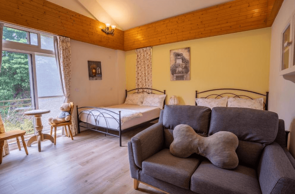 【南庄民宿】南庄普羅旺斯鄉村民宿－木質溫馨四人房，設有可愛狗骨頭造型抱枕與泰迪熊裝飾，充滿童趣與自然風情