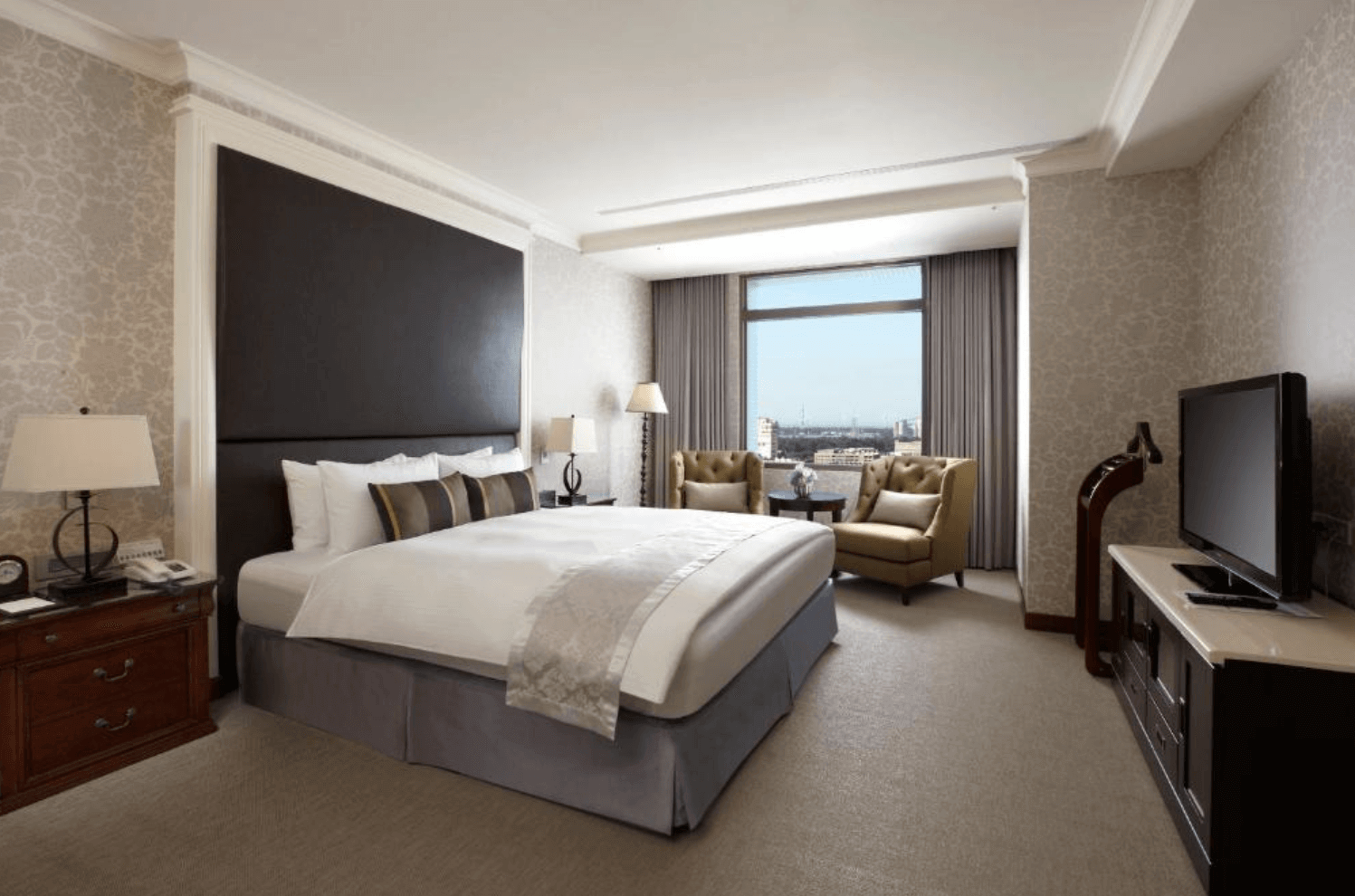 【清水住宿】台中港酒店豪華雙人房，配有大床、沙發區與落地窗，現代典雅設計風格，適合情侶或商務旅客入住。