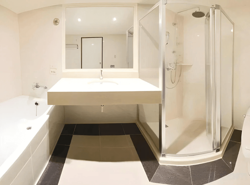 【新竹東區住宿】大道城飯店浴室設施，包含獨立乾濕分離淋浴間、浴缸與寬敞洗手台，整體設計簡潔明亮。