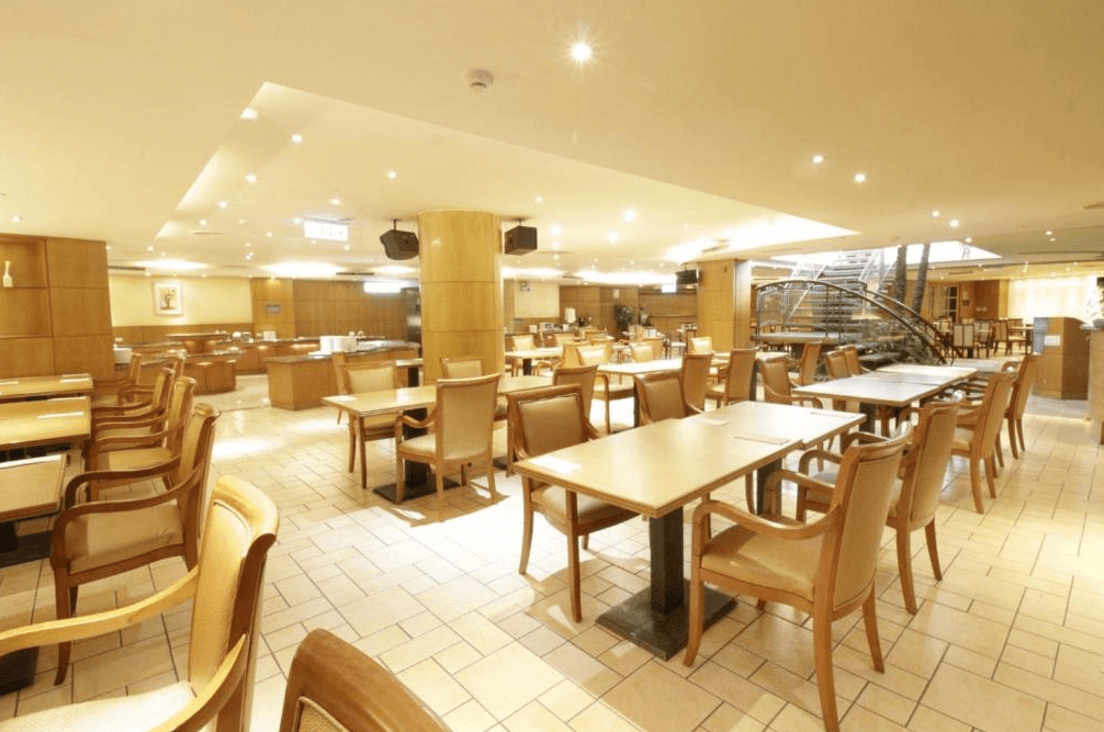 【新竹東區住宿】大道城飯店餐廳空間寬敞明亮，木質裝潢搭配大量座位區，適合旅客享用自助早餐與用餐時光。