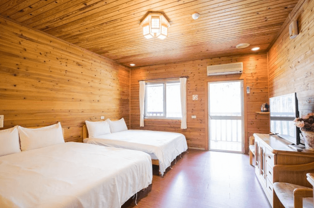 【古坑住宿】天秀山莊餐廳民宿的四人房，室內以全木質牆面與天花板打造，搭配兩張雙人床、液晶電視與簡約家具，空間溫馨自然，散發濃濃木屋風情。