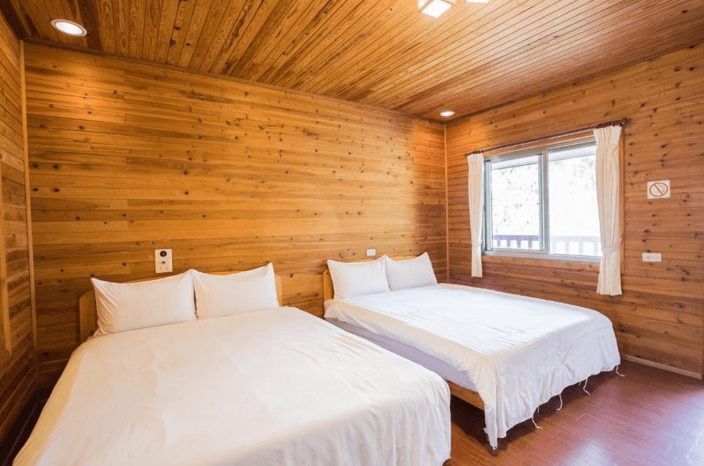 【古坑住宿】天秀山莊餐廳民宿的雙床木屋房型，設有兩張雙人床與窗景採光，整體以松木裝潢打造溫暖舒適的氛圍，適合親子或家庭入住。