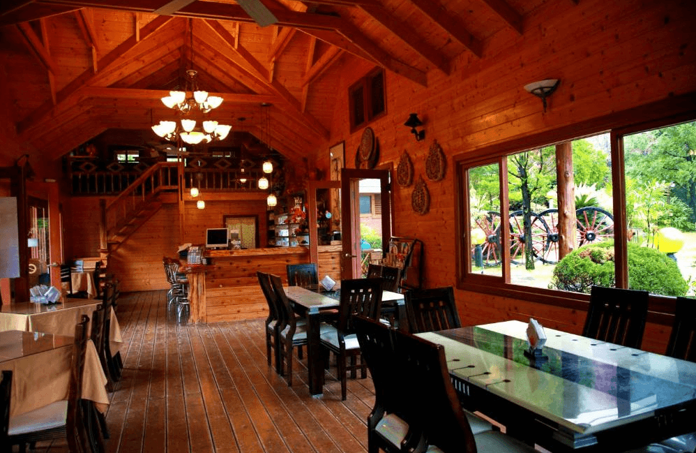 【南庄民宿】容園谷景觀渡假山莊－原木打造的景觀餐廳，大面窗戶可欣賞綠意庭園，提供旅人愜意用餐空間