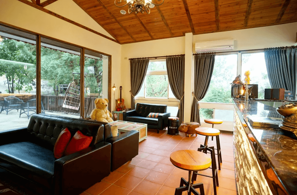 【南庄民宿】山田民宿－溫馨大廳設有多組沙發座位區與兒童玩具，大片玻璃窗可望見戶外自然綠意