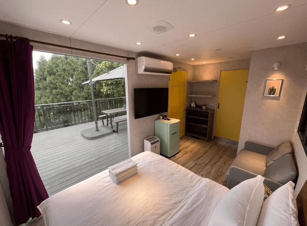 【南庄民宿】山田民宿－現代簡約風格的露營車房型，配備電視、沙發、冰箱與戶外陽台座位，享受自在住宿體驗