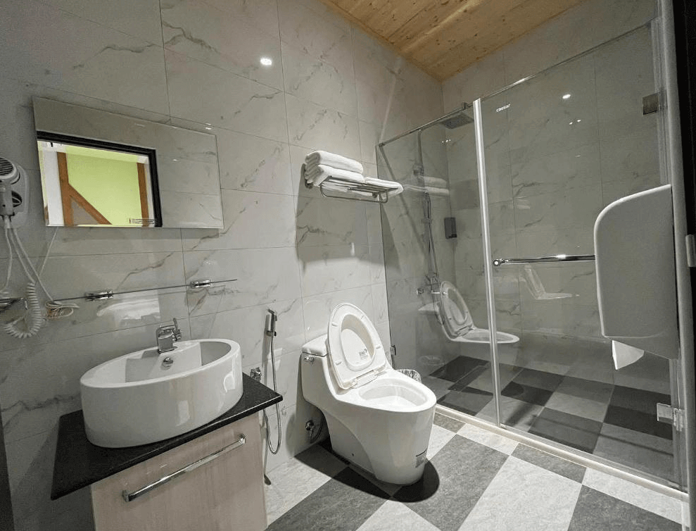 【古坑住宿】意境森林民宿的衛浴空間，設有乾濕分離淋浴間、免治馬桶與現代洗手台，牆面採大理石紋設計，整體乾淨明亮、設備完善。