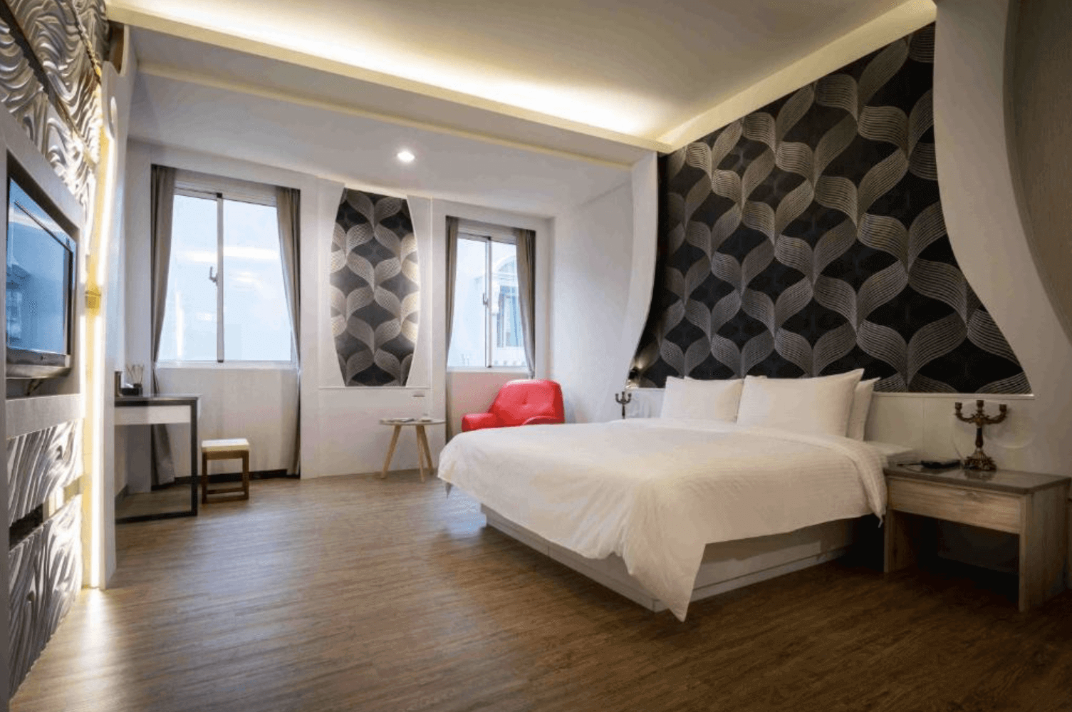 【清水住宿】愛力根汽車旅館特色雙人房，牆面採用葉片紋立體壁紙設計，搭配溫潤木地板與紅色單椅，空間感現代又舒適。