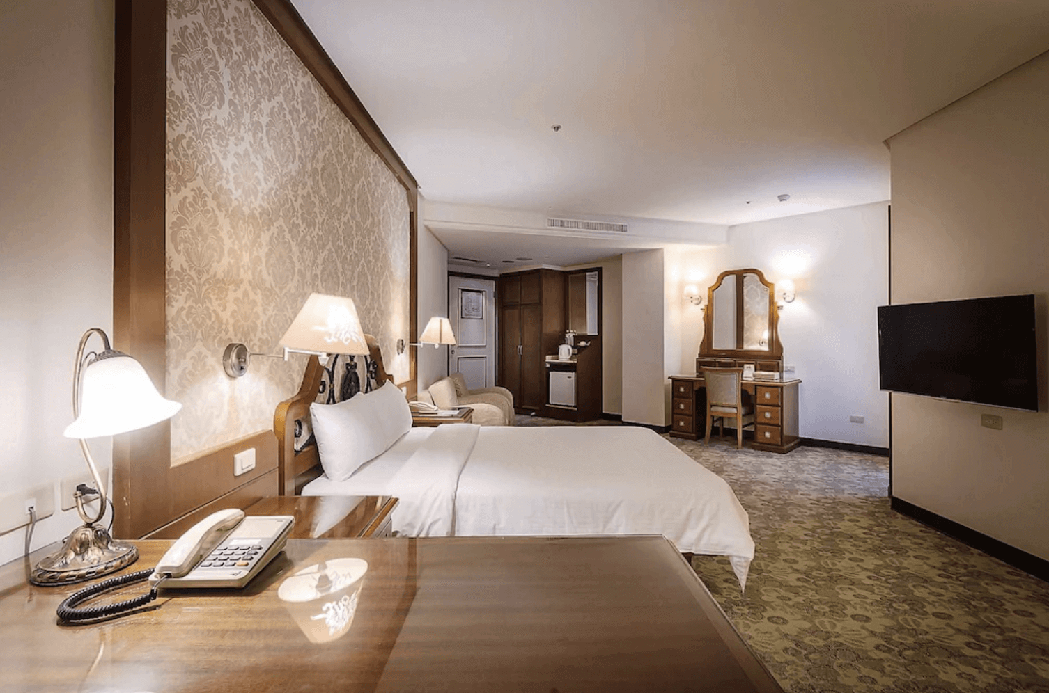 【中壢夜市住宿】承攜行旅－中壢中正館精緻雙人房，配有柔和壁燈、木質傢俱與梳妝台，空間寬敞舒適，展現歐式古典風情。