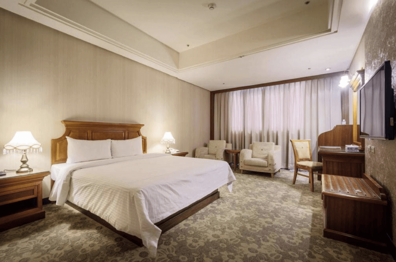 【中壢夜市住宿】承攜行旅－中壢中正館溫馨雙人房，設有大面窗簾、舒適座椅與木質桌椅，營造寧靜放鬆的住宿空間。