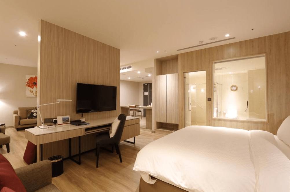 【竹北住宿】新竹安捷國際酒店商務型客房內部設計，房間寬敞，配有辦公書桌與電視，後方為乾濕分離衛浴空間，適合商務旅客入住。