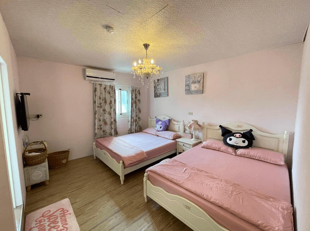 【西螺住宿】旅人路過時溫馨雙床房，牆面漆成粉色，搭配粉紅床單與卡通抱枕，華麗吊燈與碎花窗簾營造出浪漫少女風格。
