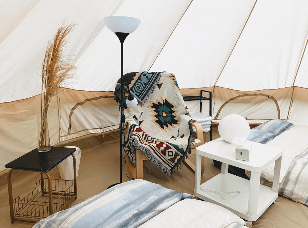 【南庄民宿】星原谷露營區－帳篷內部擺設風格溫馨，包含民族風毛毯、閱讀燈與裝飾乾燥花，打造療癒系露營空間