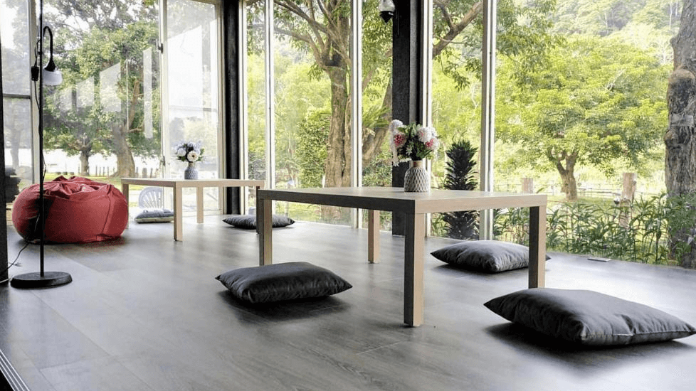 【南庄民宿】星原谷露營區－落地窗圍繞的公共交誼空間，鋪設地墊與木桌，享受自然美景與悠閒午後時光