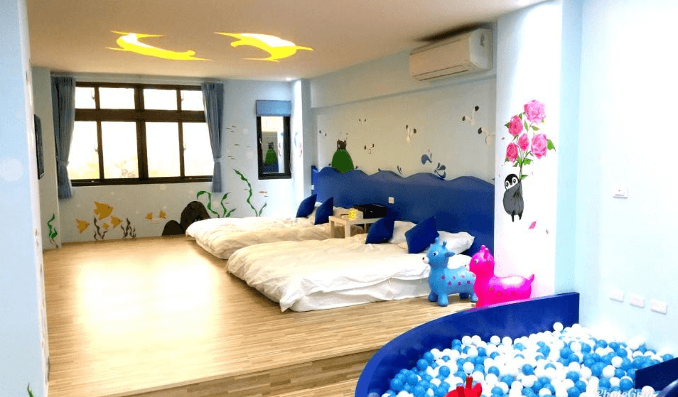 【竹山住宿】晚安熊親子民宿藍色海洋主題房型，提供三張日式床墊、大面窗戶與球池遊戲區，牆面繪有海底世界與動物圖案，適合親子同樂。