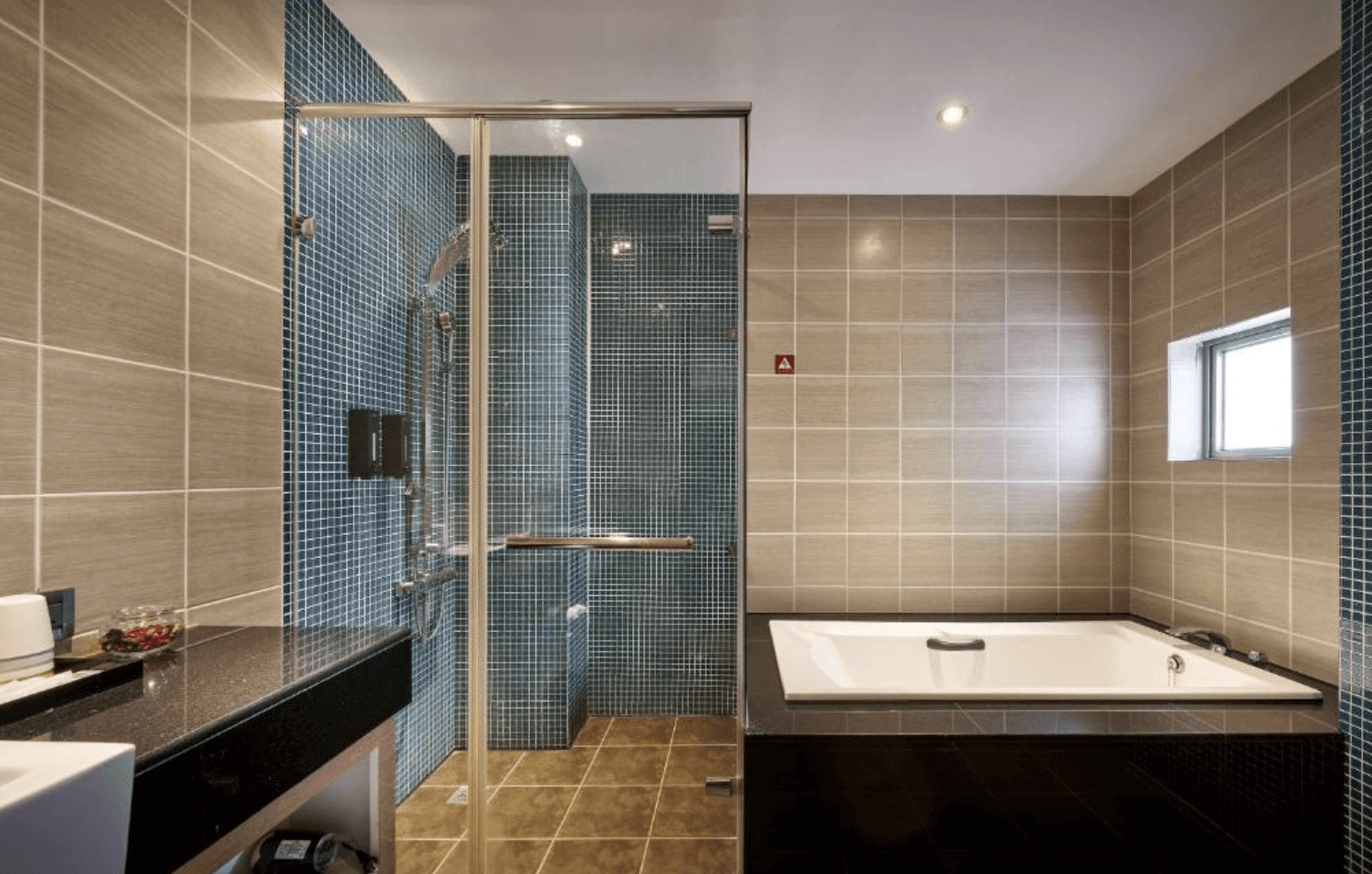【清水住宿】梧棲行旅浴室，配置大型浴缸與乾濕分離淋浴間，牆面以藍灰磁磚鋪設，空間寬敞舒適。