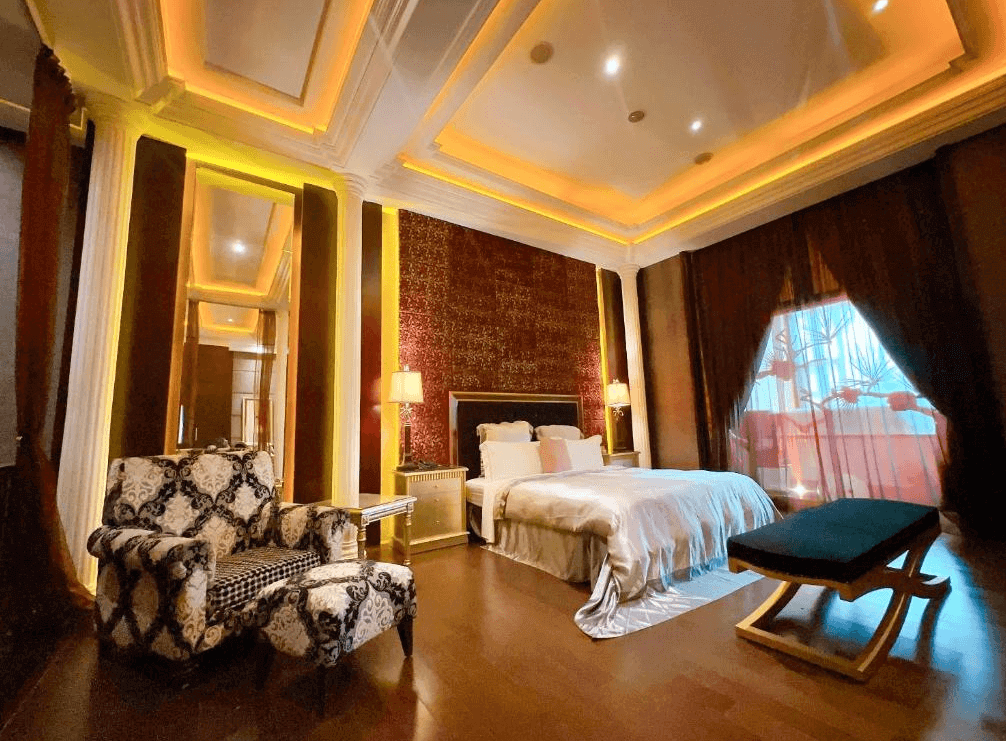 【新竹東區住宿】湖山風景旅館浪漫房型，金黃色燈光搭配絢麗天花板與紅絨牆面，附設躺椅與印花沙發椅，空間華麗溫馨。