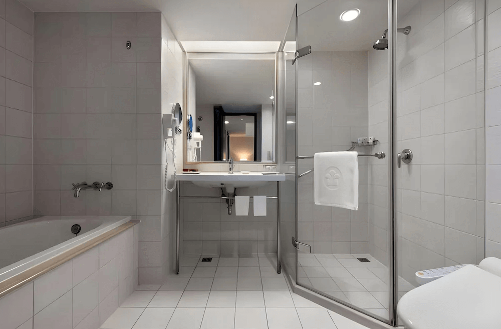 【新竹東區住宿】煙波大飯店－都會館浴室空間，配置乾濕分離淋浴間、浴缸與大片鏡面洗手台，整體潔淨明亮、設備齊全。