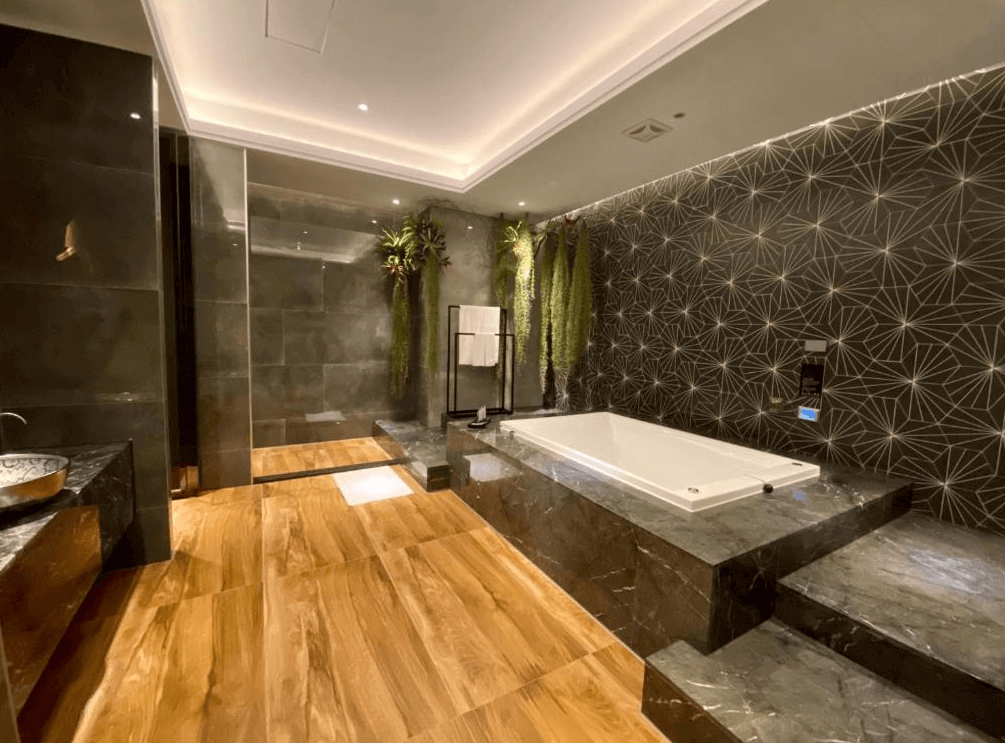 【新竹東區住宿】琺何精品旅館寬敞浴室空間，配有大型方形浴缸、黑灰色大理石設計與植栽牆面，營造低調奢華的泡湯體驗。