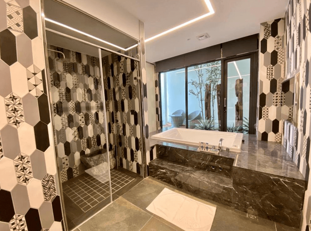 【新竹東區住宿】琺何精品旅館現代風格浴室，設有特色拼貼磁磚、獨立淋浴間與景觀泡澡區，外接戶外庭院採光充足。