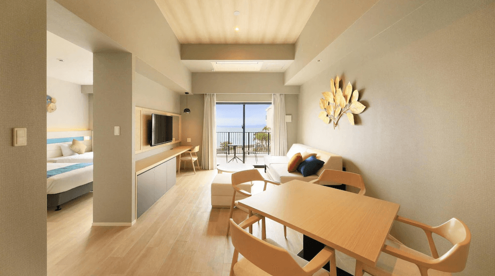 【石垣島住宿】石垣島VIVOVIVA一室設計，臥室與客廳連通，簡約木質家具搭配牆面金色裝飾，陽台外即是無敵海景。