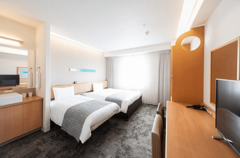 【石垣島住宿】石垣島船屋飯店雙床客房，設計簡約明亮，設有兩張單人床、書桌、電視與洗手台，空間乾淨整潔，適合雙人入住。