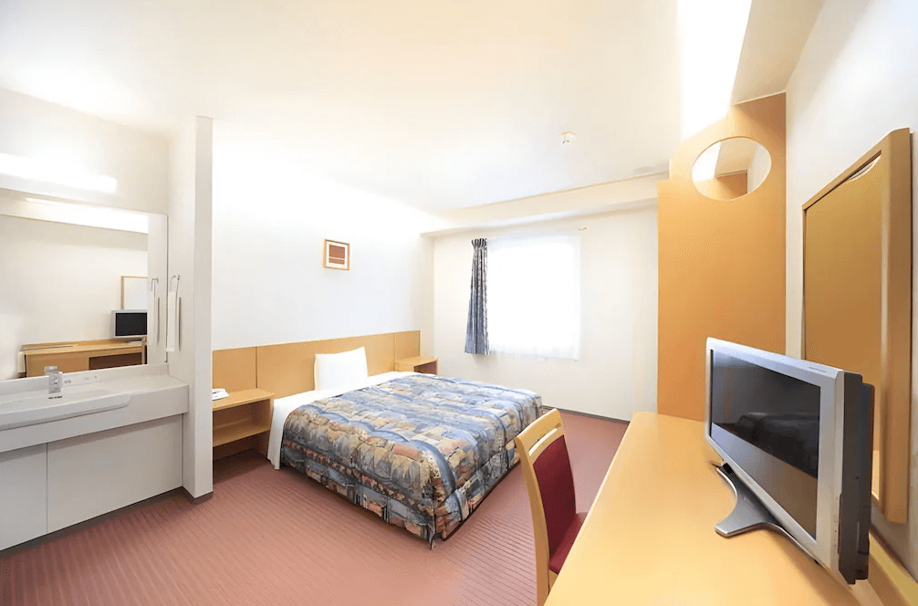 【石垣島住宿】石垣島船屋飯店單人房，配有一張大床與溫馨書桌區，室內風格溫暖樸實，設有洗手台與簡約裝潢，適合一人旅行或商務客入住。