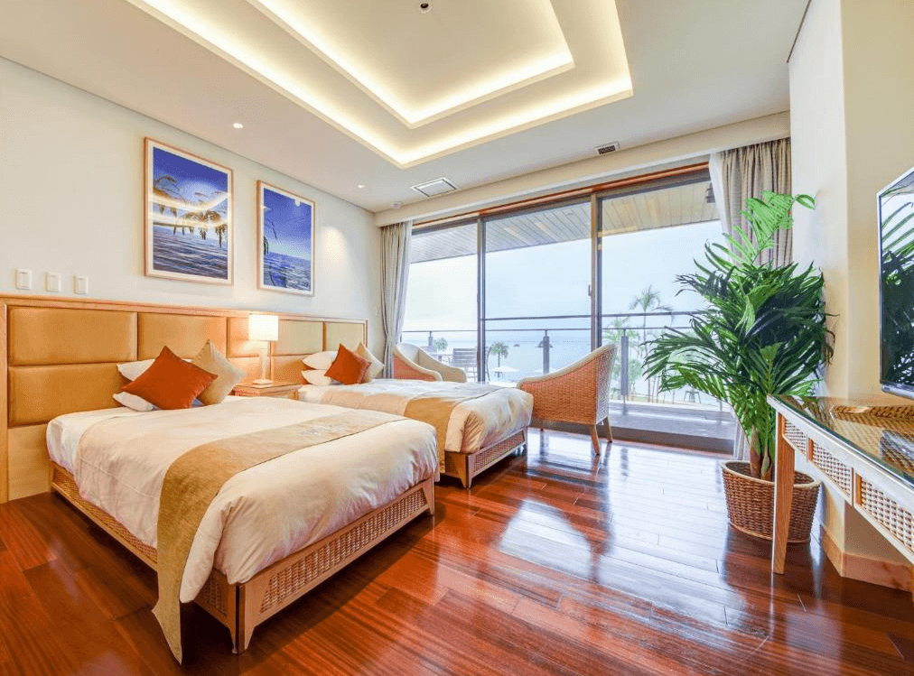【石垣島住宿】石垣度假飯店海景雙床房，房內設有木質地板、溫暖燈光、現代裝潢與陽台，可遠眺海景與椰子樹。