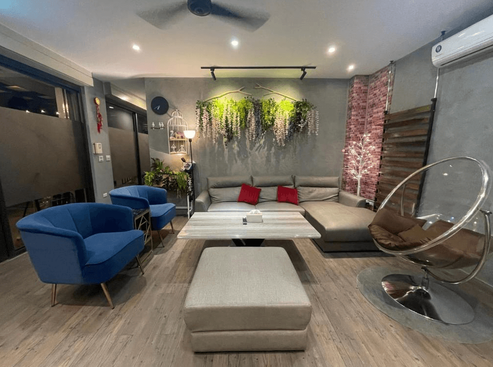 【竹山住宿】竹山。鄉間小路共用客廳空間，擺設多樣沙發與吊椅，牆面掛有植栽與燈飾裝飾，營造出現代工業風與自然融合的放鬆氛圍。