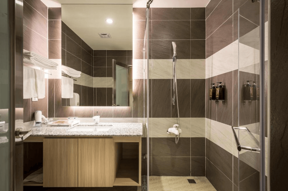 【西螺住宿】米都商務飯店的現代化衛浴空間，採乾濕分離設計，搭配灰白相間磁磚與大片鏡面，設施齊全整潔明亮。